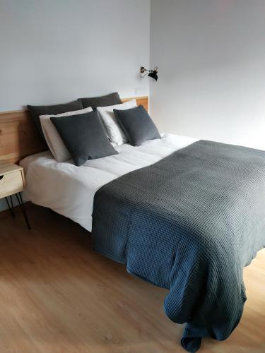 a bedroom with a large bed with black and white pillows at Janela do Porto in Prainha de Baixo