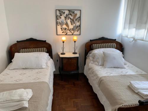 a room with two beds and a table with two lamps at Mirador de Plaza España in Cordoba