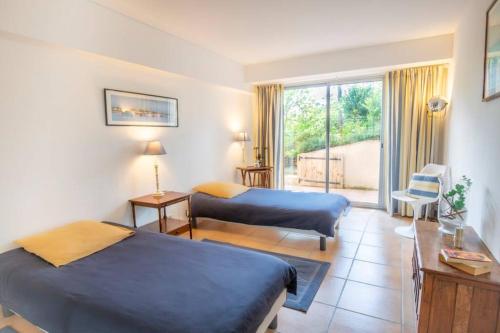una camera d'albergo con due letti e un balcone di Forest flat / Terrasse-spa-bbq-10min à pieds de la plage a La Teste-de-Buch