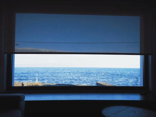a view of the ocean through a window at Janela do Porto in Prainha de Baixo