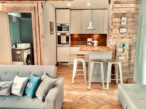 Una sala de estar con un sofá y una cocina. en Pärnu Apartment, en Pärnu