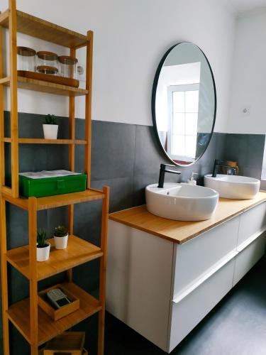 a bathroom with two sinks and a mirror on a counter at Janela do Porto in Prainha de Baixo