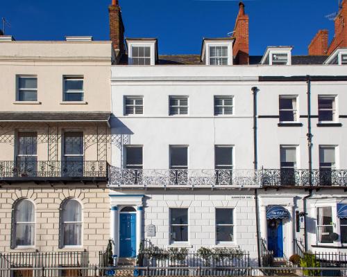 a white house with blue doors and windows at No. 98 Boutique Hotel in Weymouth