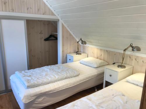 two beds in a room with two lamps on tables at Fogelbergs TuB in Visby