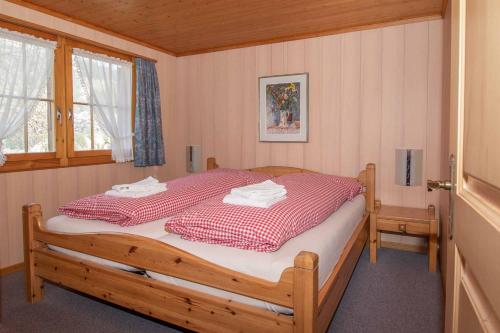 a bedroom with a bed with a red and white blanket at Chalet Iris in Adelboden