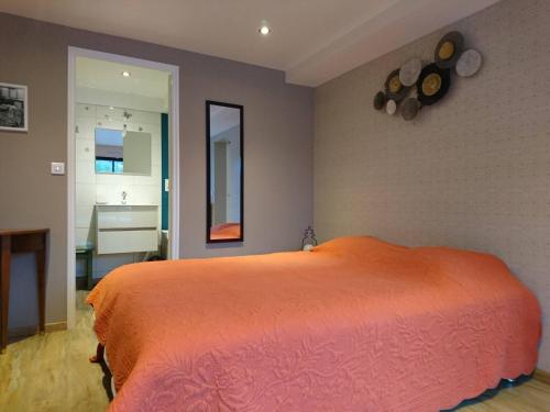 a bedroom with a large orange bed and a bathroom at Appartement Belle Vue in Gérardmer