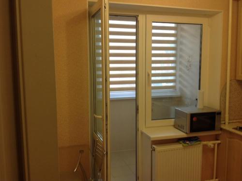 a kitchen with a window and a microwave on a counter at Samson Apartments in Velikiy Novgorod