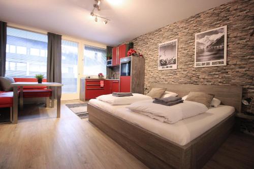 een slaapkamer met een groot bed en een bakstenen muur bij Retro Apartment in Kaprun