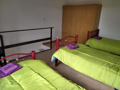um quarto com duas camas com lençóis verdes em Apart Estepa em El Calafate