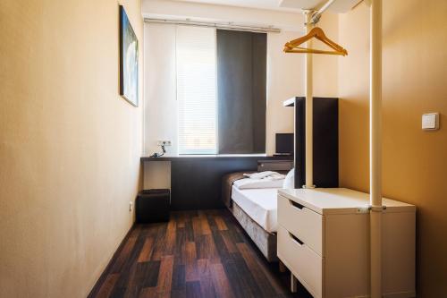 um quarto com uma cama, uma cómoda e uma janela em Apple City Hotel em Berlim