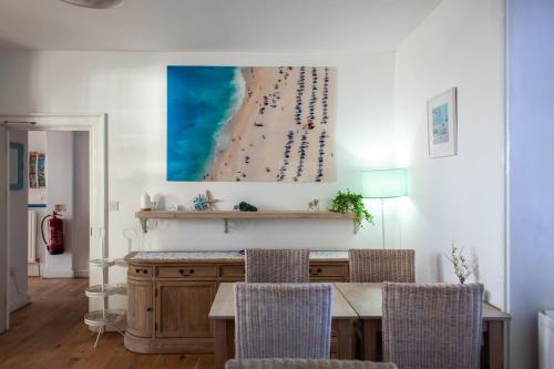 a dining room with a table and a picture of a beach at No. 98 Boutique Hotel in Weymouth