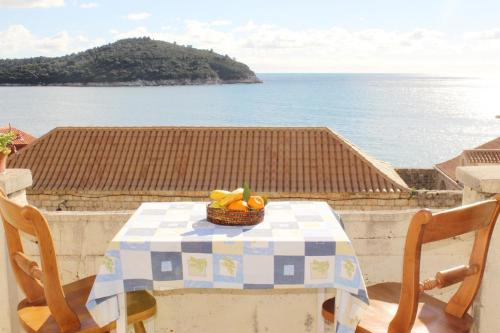 a table with a basket of fruit on a balcony at Rooms Lazareti in Dubrovnik