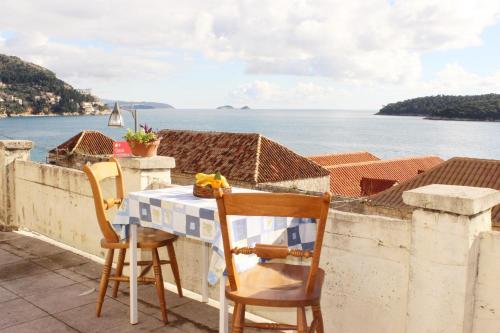 una mesa y sillas en un balcón con vistas al agua en Rooms Lazareti, en Dubrovnik
