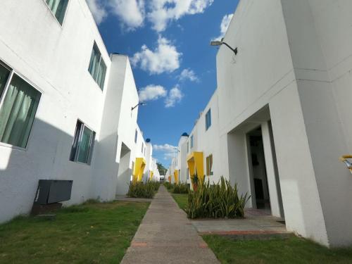 an alley between two white buildings with a blue sky at CIC Apartamento amoblado Mirador del Sinú in Montería