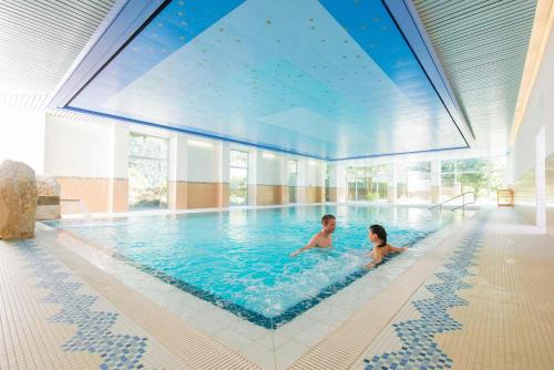 2 niños nadando en una gran piscina en Badehotel Salina Maris – Wellness & Vintage, en Mörel