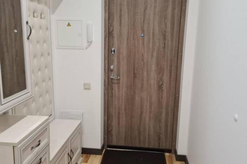 baño con puerta de madera en una habitación en ForestLove en Klaipėda