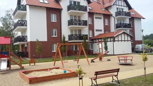 a playground in front of a large apartment building at Apartament dla Ciebie in Sztutowo