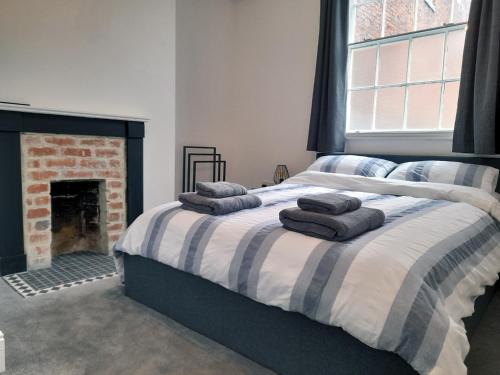 um quarto com uma cama com almofadas em Eastgate Hideaway - central, luxury apartment on Chester's historic rows em Chester