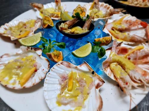 a plate of food with oysters and lime slices at Regina City Hotel & SPA in Vlorë
