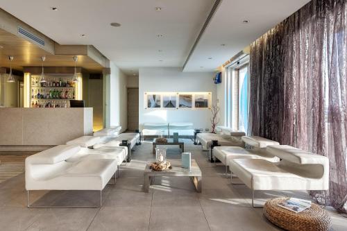 a living room with white couches and a bar at Smy Aran Blu Roma Mare in Lido di Ostia