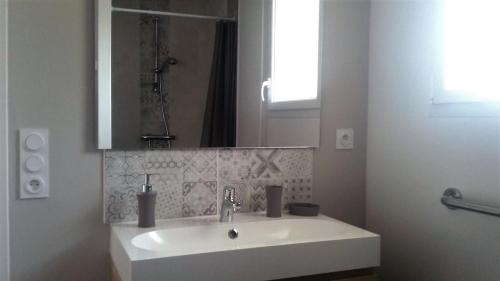 bagno bianco con lavandino e specchio di L'Atelier a Fréhel
