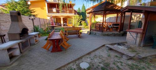 a patio with a table and benches and a building at Penzión Korzo in Štúrovo