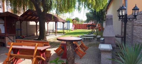 a patio with a table and benches and a playground at Penzión Korzo in Štúrovo