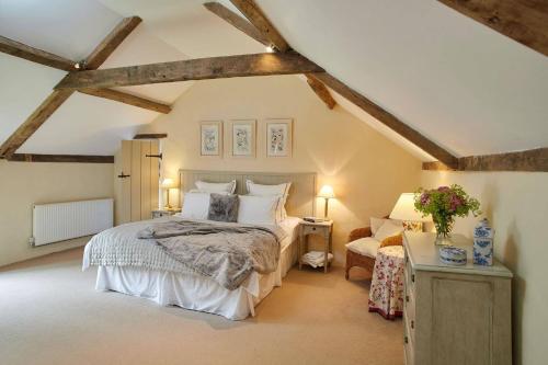 a bedroom with a large bed and a chair at Banningham Coach House in Ingworth