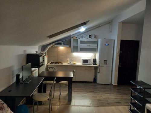 a small kitchen with a table and a refrigerator at Apartament 2 camere in Chiajna