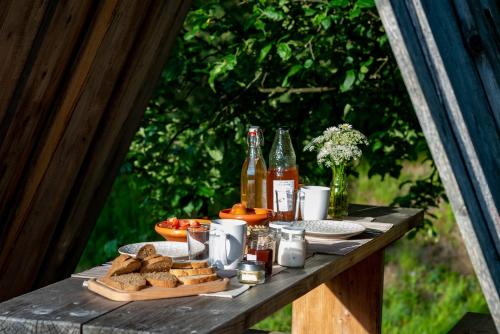 einen Picknicktisch mit Brot und Flaschen Bier und Getränke in der Unterkunft Glamping - Ekološka kmetija Kozman in Žalec