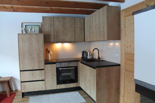 a kitchen with wooden cabinets and a stove at Chalet am wilden Kaiser in Kirchdorf in Tirol