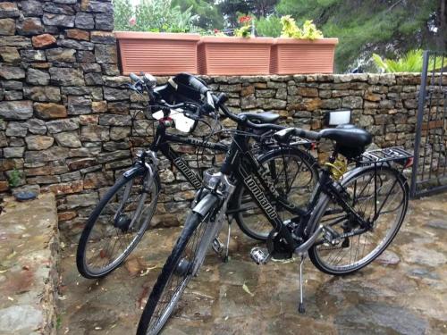 twee fietsen geparkeerd naast een stenen muur bij Terra Sinus Beautiful Suite in Terrasini