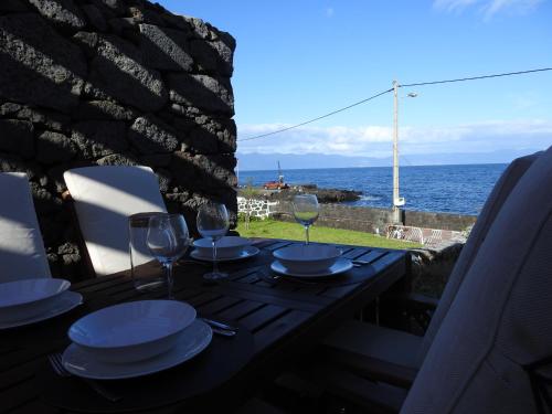 a table with plates and wine glasses on a balcony at Janela do Porto in Prainha de Baixo