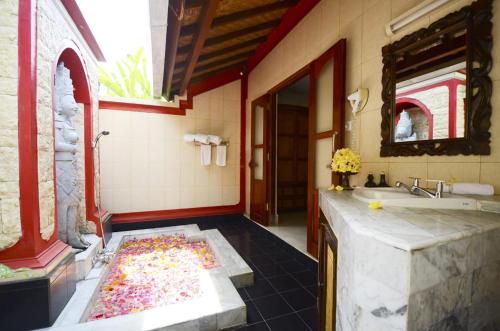 a bathroom with a bath tub and a sink at Tirta Ayu Hotel and Restaurant in Tirtagangga