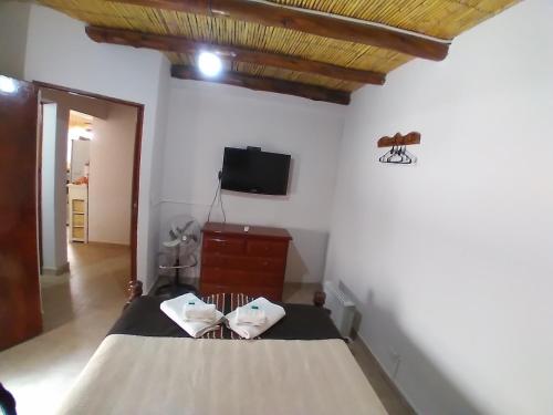 a bedroom with a bed and a tv on the wall at Los Agustinos in Purmamarca