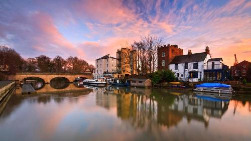a view of a river with buildings and a bridge at La casetta d'Àneu in Oxford