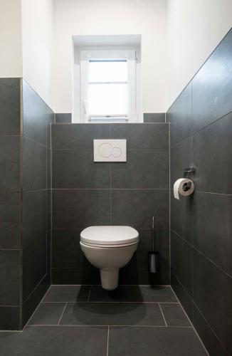 a bathroom with a toilet and a window at Apartpension Kappacher in Kaprun