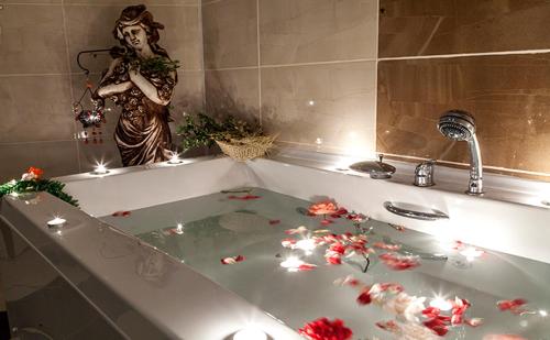 a woman standing in a bath tub with flowers in it at GARDEN KALE THERMAL HOTEL in Afyon