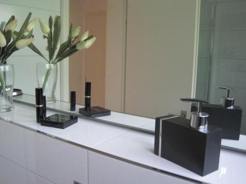 a bathroom counter with a mirror and a vase with flowers at Appartement Panoramablick in Baden-Baden