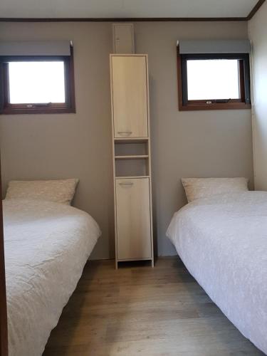 een kamer met twee bedden en een kast erin bij Reewold Veluwe in Putten