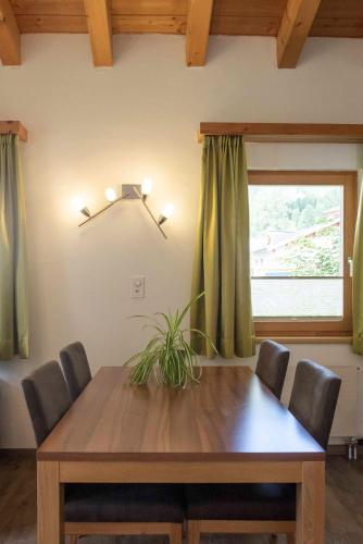 a dining room table with chairs and a window at Apartment Madlaina in Samnaun