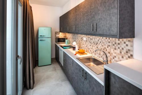a kitchen with a green refrigerator and a sink at Thiramor houses in Mesaria