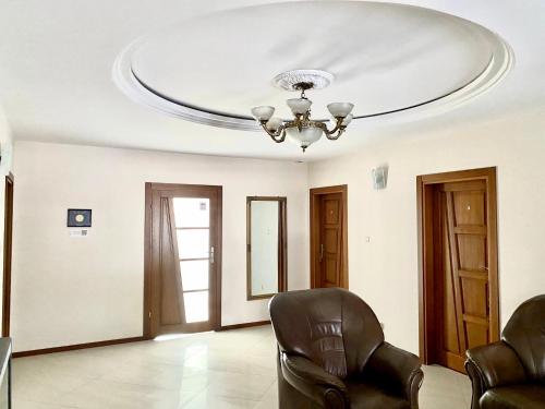 a living room with a ceiling with a chandelier at Agroturystyka Pod Jodłami in Kołaki Wietrzychowo