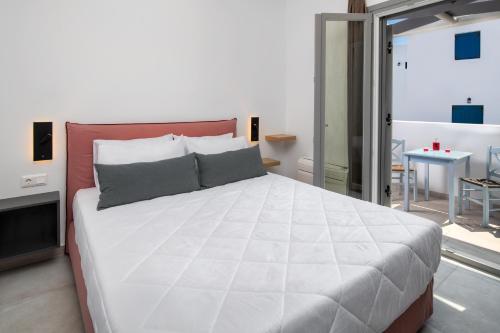 a large white bed in a room with a table at Thiramor houses in Mesaria