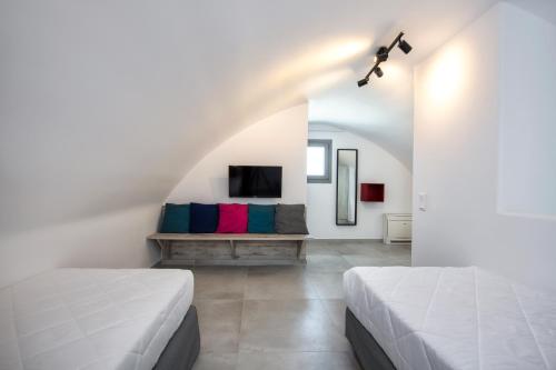two beds in a white room with a tv at Thiramor houses in Mesaria