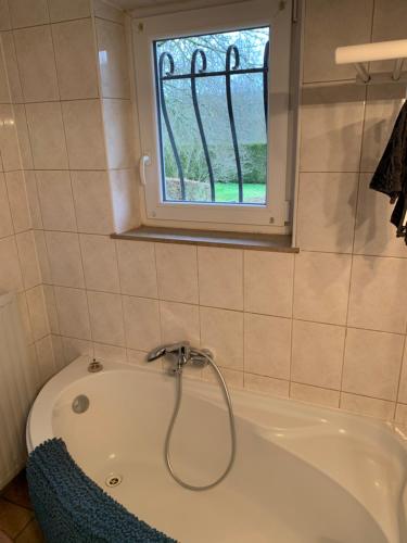 a bath tub in a bathroom with a window at Étoile de Laforêt in Laforêt