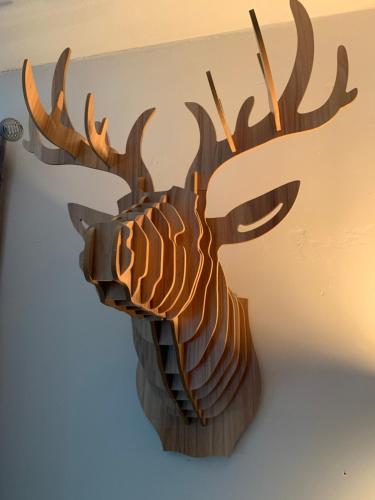 a wooden reindeer head hanging on a wall at Étoile de Laforêt in Laforêt
