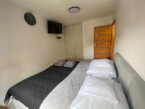 a small bedroom with a bed and a tv at Apartament Dwupoziomowy - klimatyzacja in Słupsk
