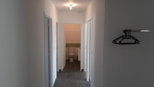 pasillo que conduce a un baño con aseo en Maison entière moderne tout confort de 92m², en Angulema