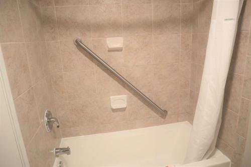 a bathroom with a shower with a white tub at Baymont by Wyndham Norcross Atlanta in Norcross
